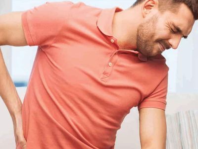 middle aged man bending over in pain and holding his back looking for a natural pain relief cream